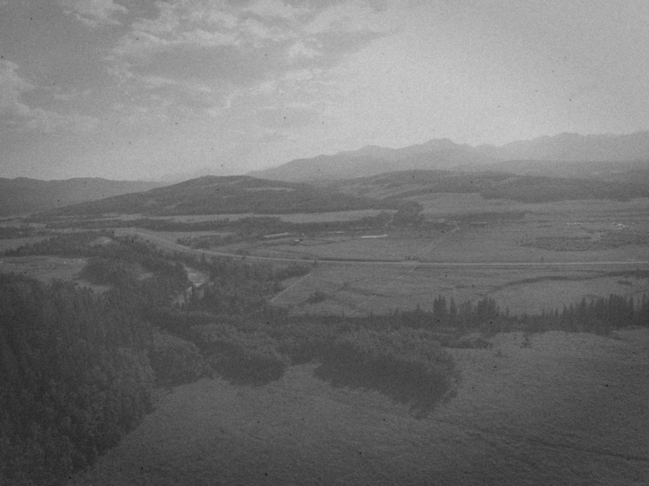 Aerial view of ranch grassland and river flats running west toward the Rocky Mountains